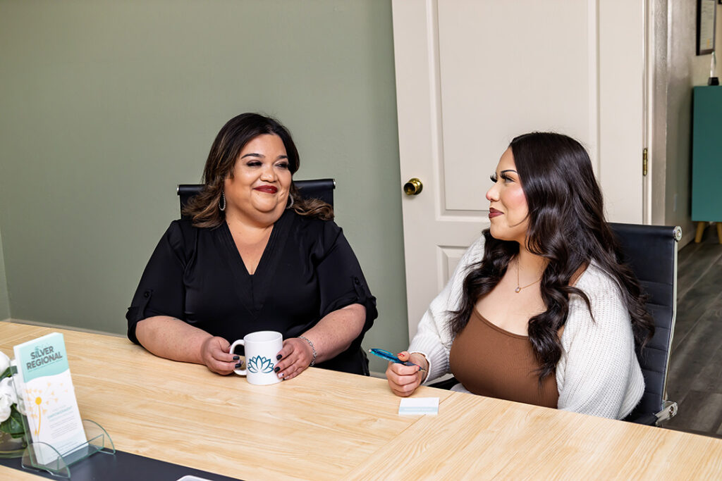 Two women smiling at one another
